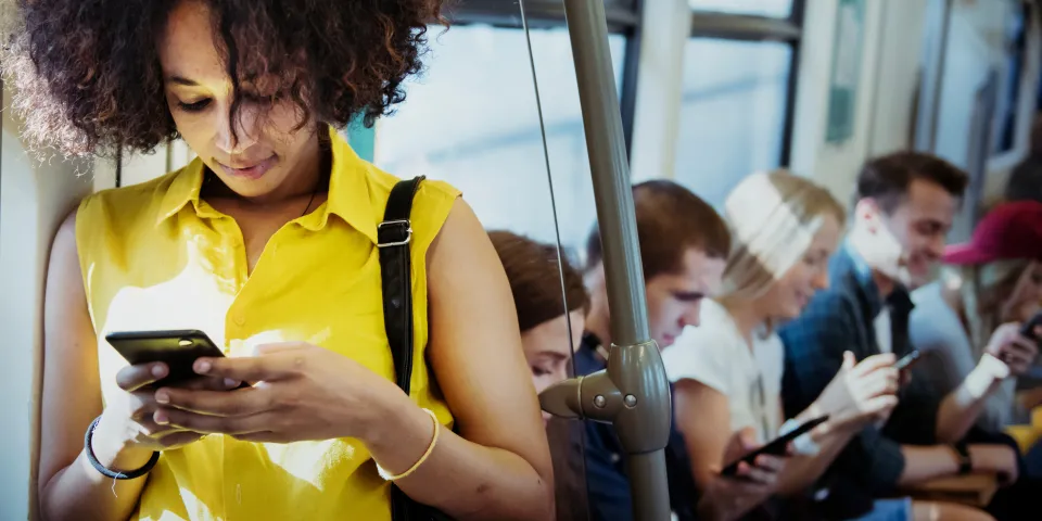 woman looking at phone on subway