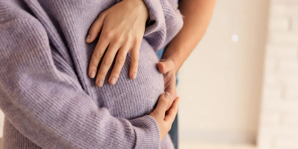 Pregnant woman and man. Happy couple, wife and husband hugging tummy